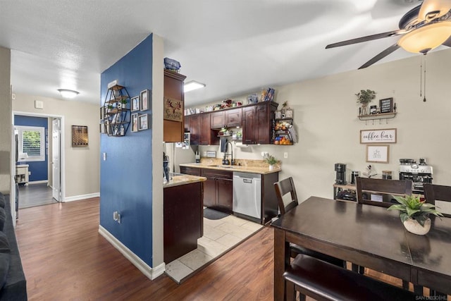 kitchen with stainless steel dishwasher, ceiling fan, sink, and light hardwood / wood-style floors