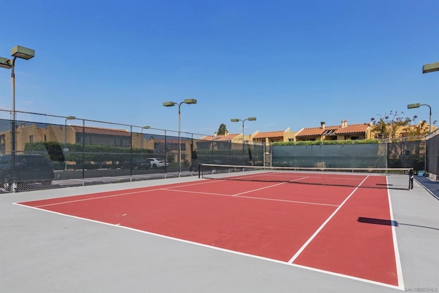 view of tennis court with basketball hoop