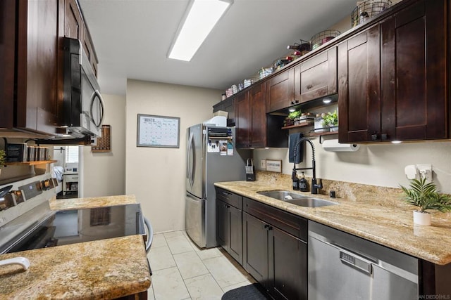 kitchen featuring stainless steel appliances, light stone counters, dark brown cabinetry, and sink