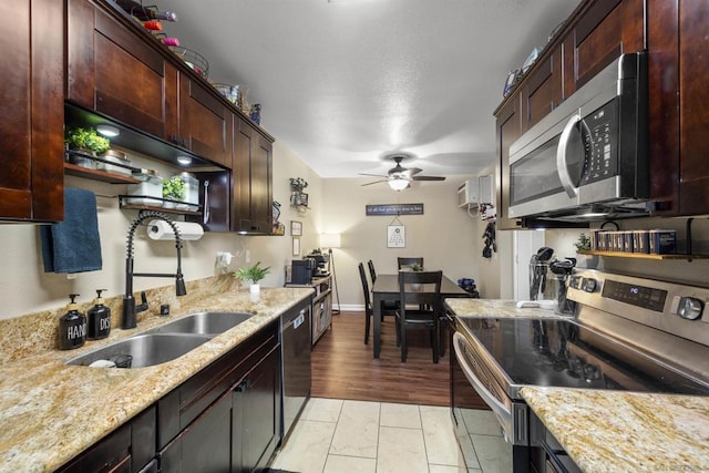 kitchen with ceiling fan, stainless steel appliances, light stone counters, and sink