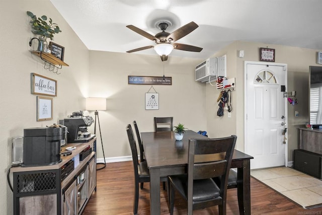 dining space featuring ceiling fan, hardwood / wood-style flooring, and an AC wall unit