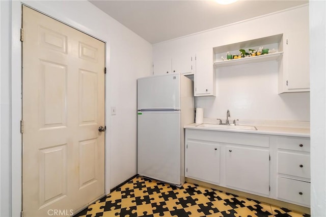 kitchen with sink, white cabinets, and white fridge