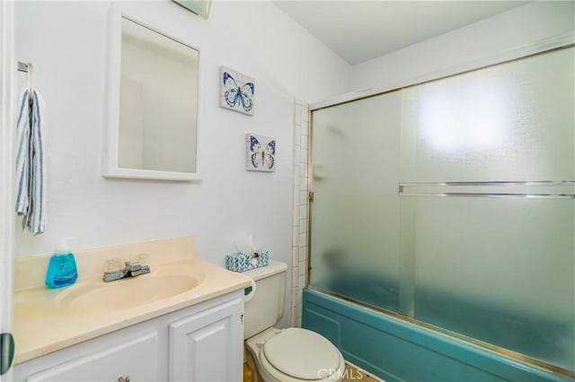 full bathroom featuring toilet, bath / shower combo with glass door, and vanity