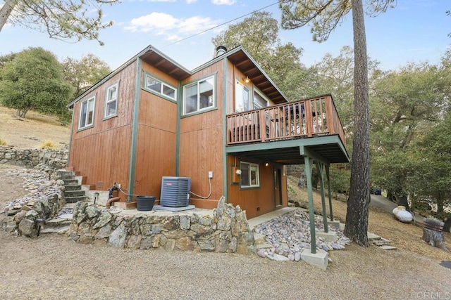 back of house with central AC unit and a wooden deck