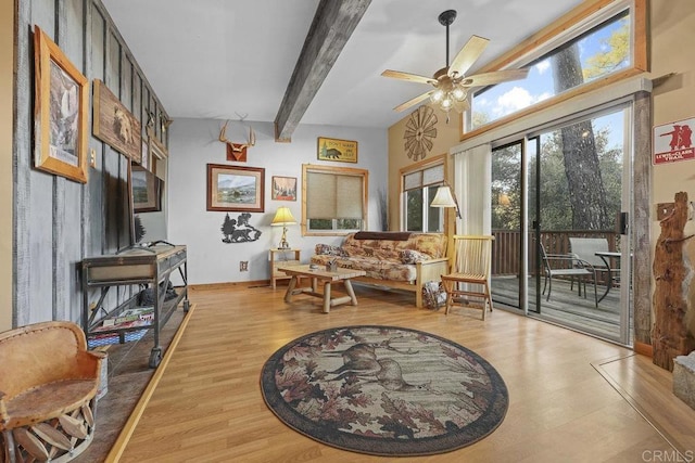 living area featuring ceiling fan, light wood-type flooring, and beam ceiling