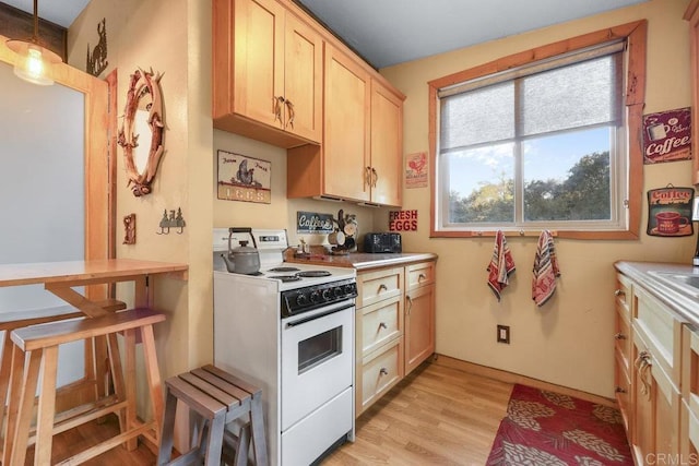 kitchen with a healthy amount of sunlight, white range, decorative light fixtures, and light brown cabinets