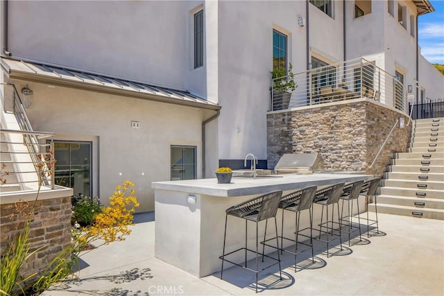 view of patio featuring an outdoor wet bar and area for grilling