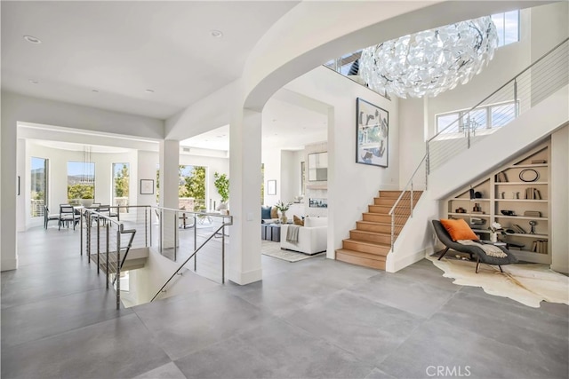 foyer featuring a notable chandelier and concrete flooring