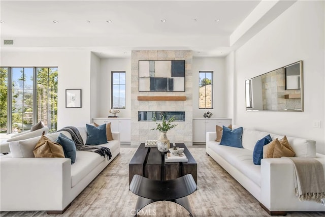 living room with plenty of natural light and a tile fireplace