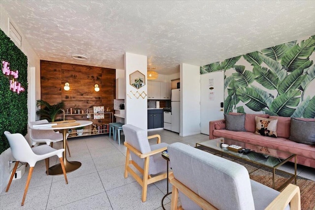 living room with a textured ceiling and wooden walls