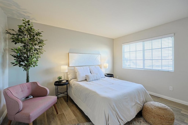 bedroom with baseboards and wood finished floors