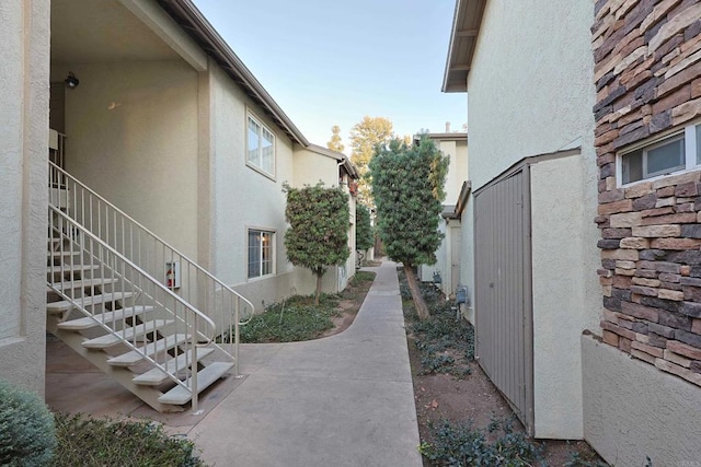 view of home's exterior with stairway, a patio, and stucco siding