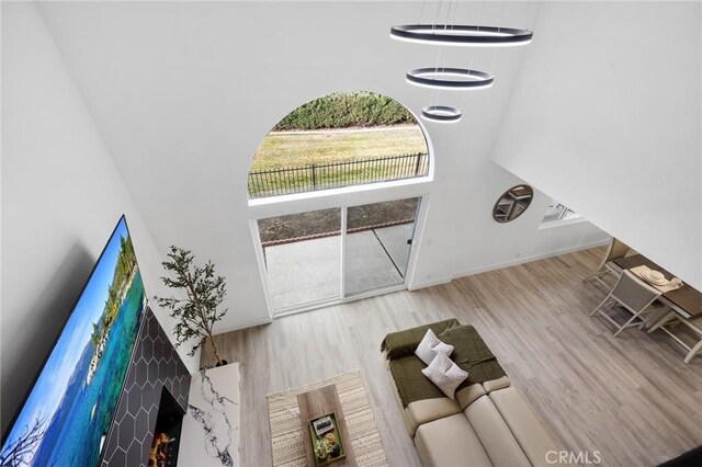 unfurnished living room with a fireplace, light hardwood / wood-style flooring, and a high ceiling