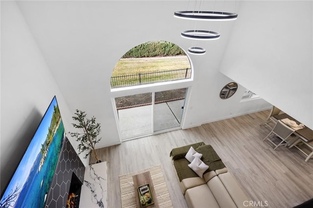 unfurnished living room featuring a fireplace, a high ceiling, and light hardwood / wood-style floors