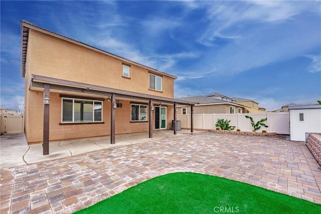 rear view of house with a shed and a patio area