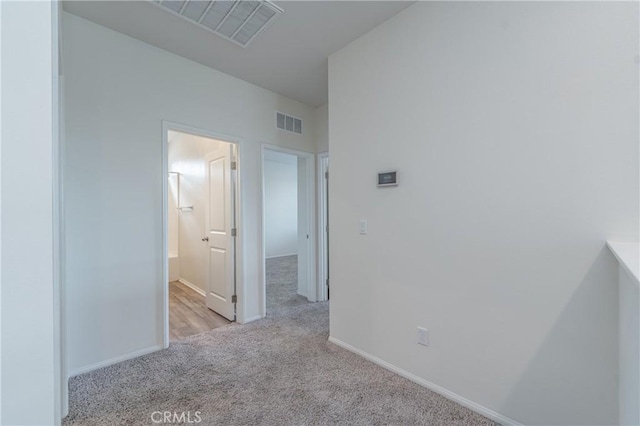 hallway with light colored carpet