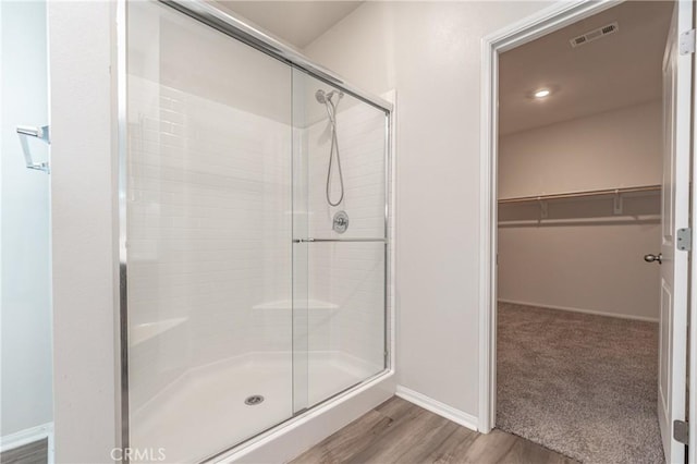 bathroom with wood-type flooring and walk in shower