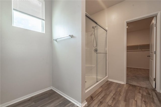 bathroom with hardwood / wood-style flooring and walk in shower