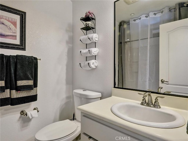 bathroom featuring curtained shower, toilet, and vanity