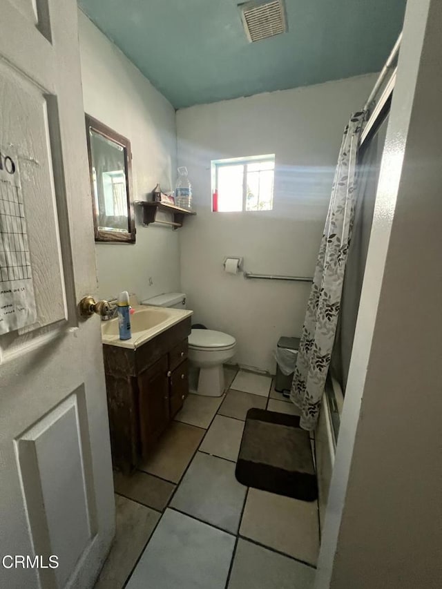 full bathroom featuring toilet, tile patterned floors, shower / tub combo with curtain, and vanity