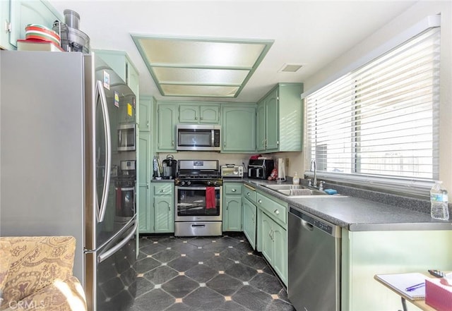 kitchen featuring stainless steel appliances, sink, and green cabinetry