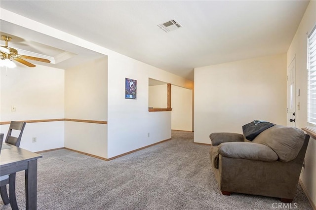 sitting room with carpet, ceiling fan, and a tray ceiling