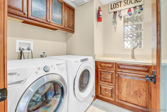 washroom with sink, cabinets, and washer and dryer