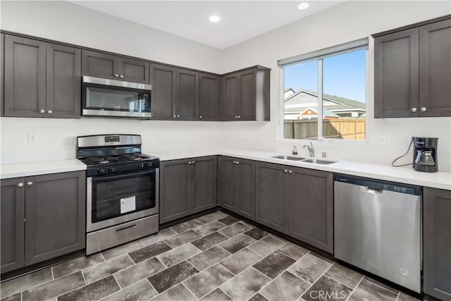 kitchen featuring stainless steel appliances, dark brown cabinets, and sink