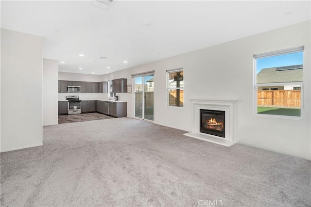 unfurnished living room with light colored carpet