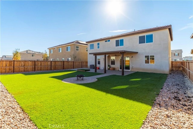 back of property featuring a lawn, an outdoor fire pit, and a patio