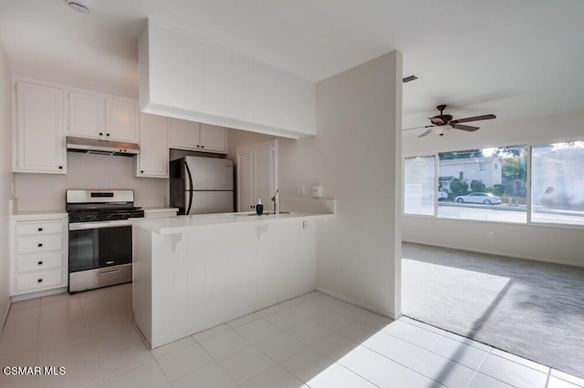 kitchen with white cabinetry, a breakfast bar area, ceiling fan, kitchen peninsula, and stainless steel appliances