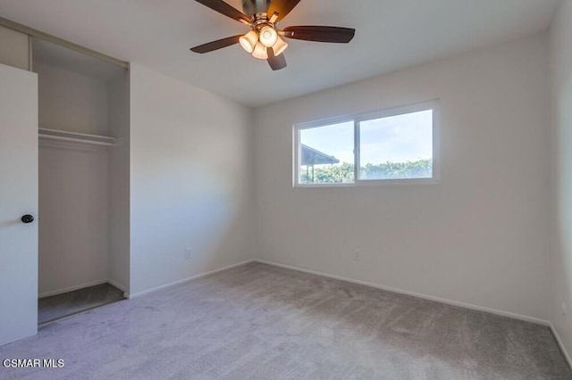 unfurnished bedroom featuring ceiling fan, a closet, and carpet