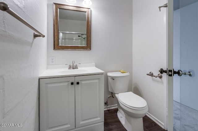 bathroom featuring vanity, hardwood / wood-style flooring, and toilet