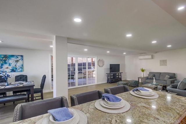 dining space with a wall mounted AC and hardwood / wood-style flooring