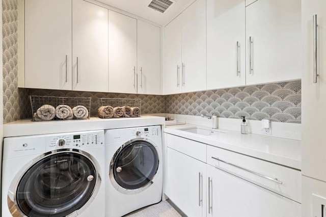 laundry room featuring sink, separate washer and dryer, and cabinets