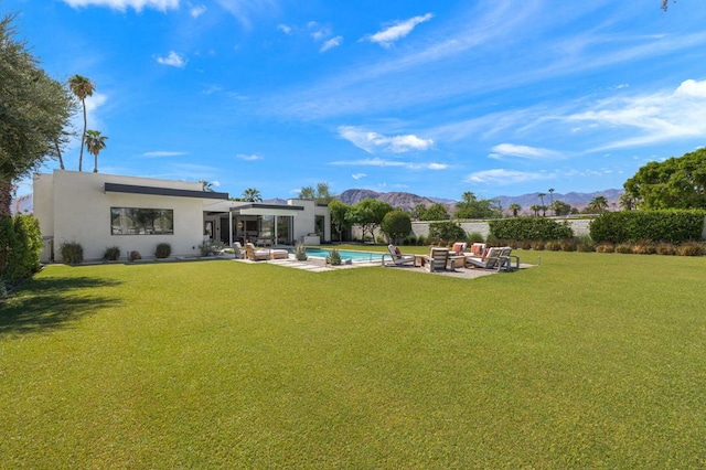 view of yard featuring an outdoor hangout area, a patio, a mountain view, and a fenced in pool