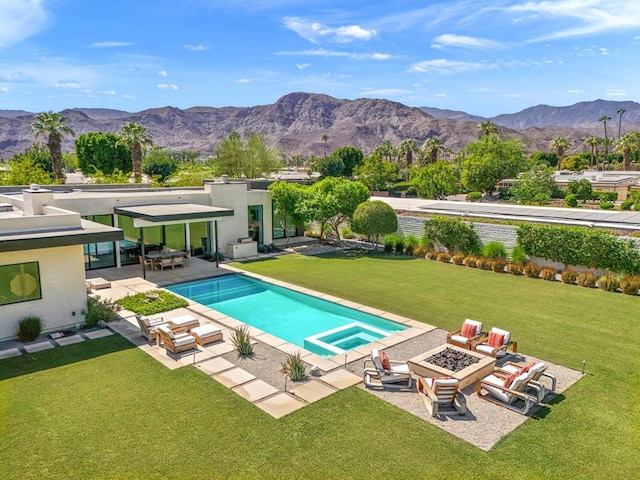 view of pool featuring a patio area, a lawn, a mountain view, and a fire pit