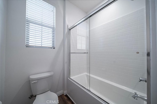 bathroom featuring toilet, enclosed tub / shower combo, and hardwood / wood-style flooring