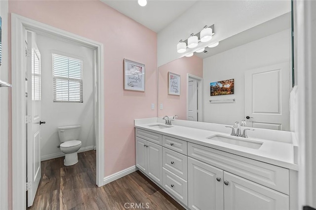 bathroom featuring toilet, hardwood / wood-style floors, and vanity