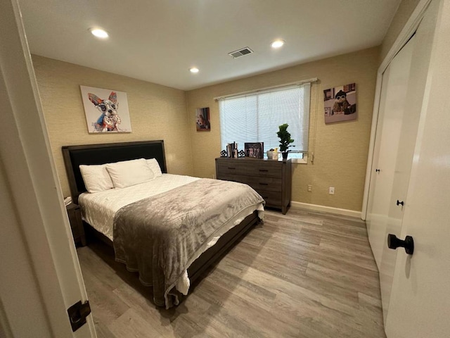 bedroom with a closet and light hardwood / wood-style flooring