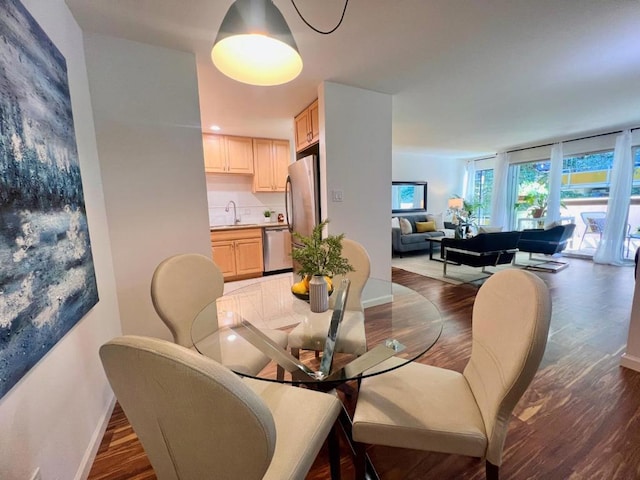 dining space featuring dark wood-type flooring and sink