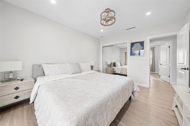 bedroom with light wood-type flooring and a closet