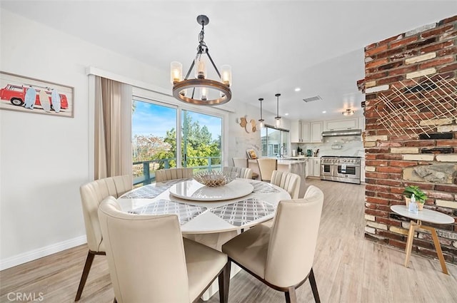 dining space with a chandelier and light hardwood / wood-style floors