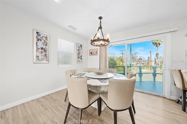 dining room featuring a notable chandelier and light wood-type flooring