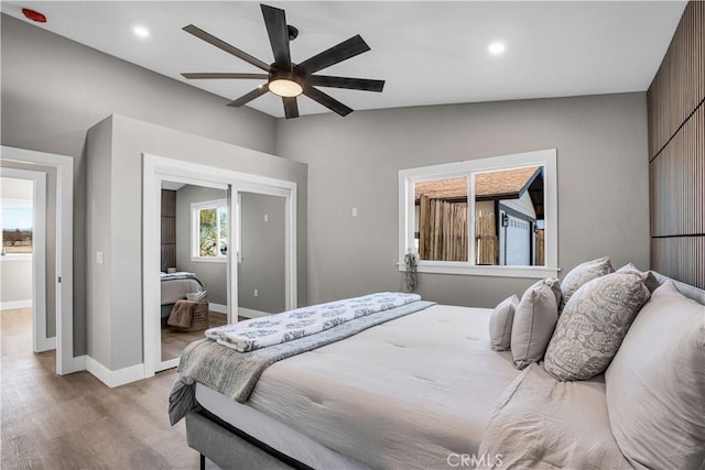 bedroom with ceiling fan, light hardwood / wood-style flooring, and vaulted ceiling