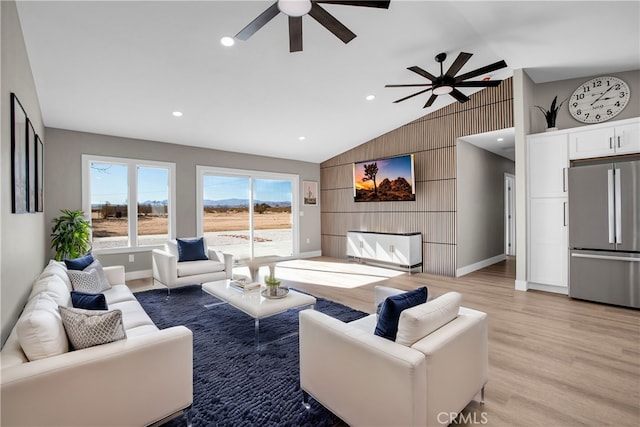 living room featuring light hardwood / wood-style floors, wood walls, ceiling fan, and vaulted ceiling