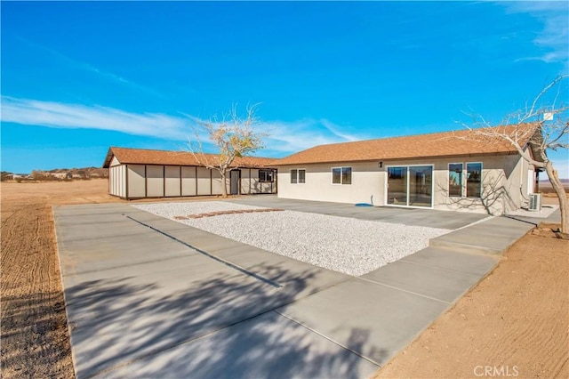 rear view of house featuring a storage shed and a patio