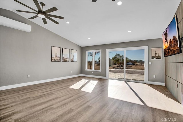 interior space with light wood-type flooring, ceiling fan, lofted ceiling, and an AC wall unit