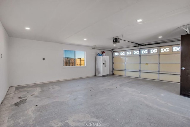 garage with a garage door opener and white fridge with ice dispenser