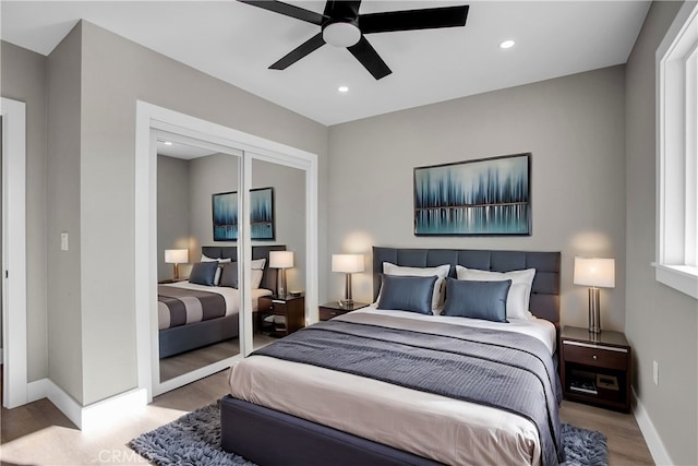 bedroom with ceiling fan, a closet, and light hardwood / wood-style floors